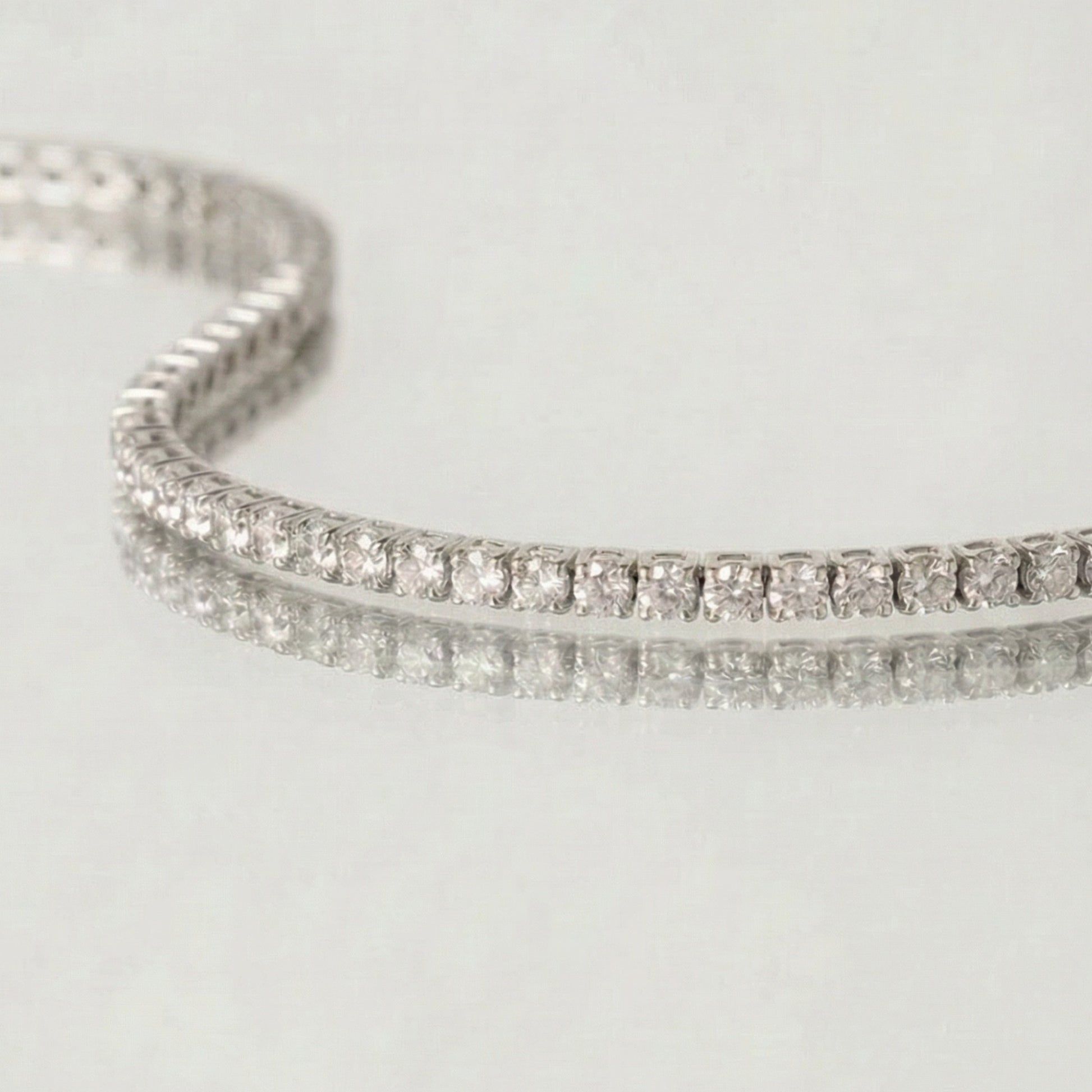 Silver bracelet with clear stones on a light gray background