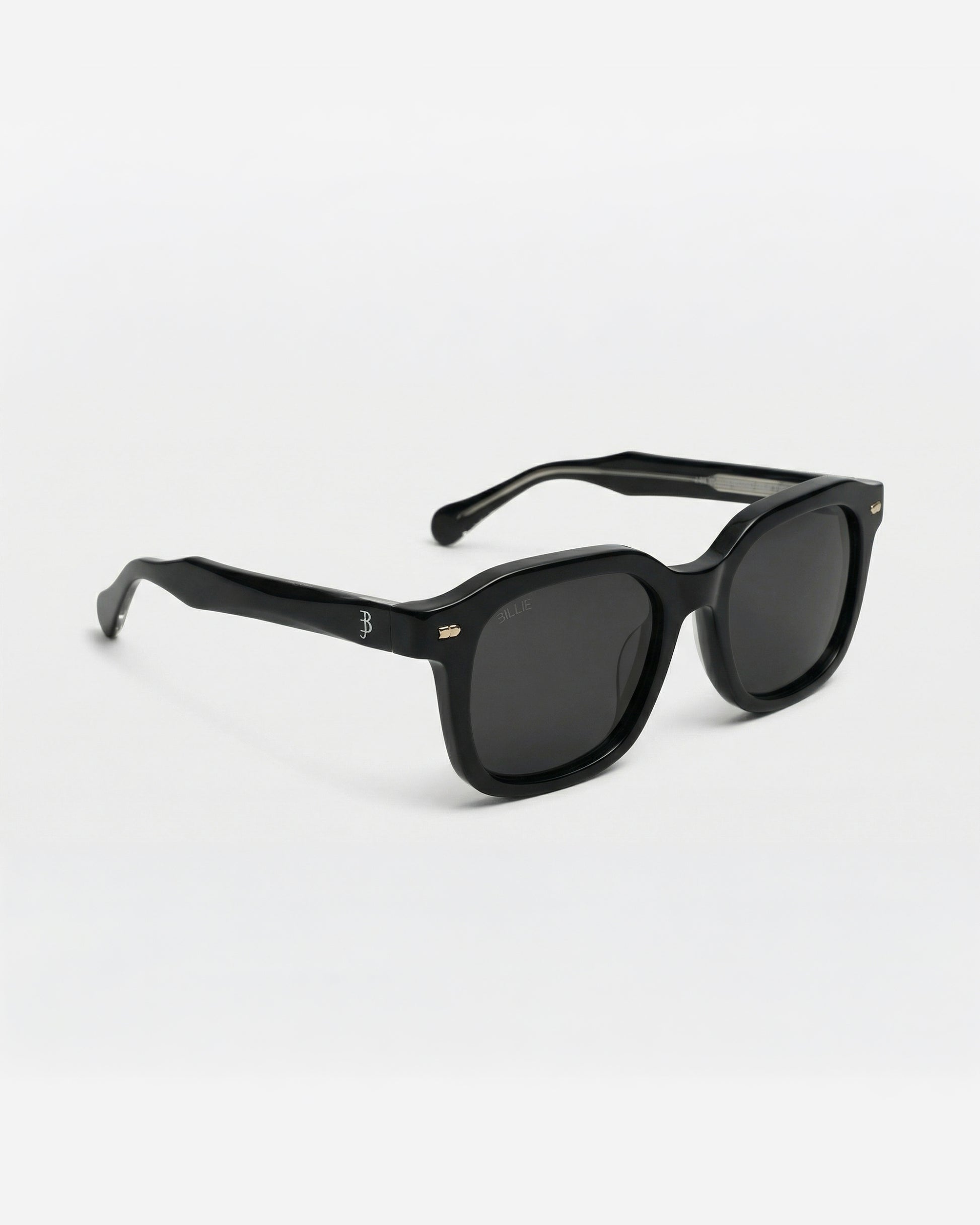 Black sunglasses with a thick frame on a plain background