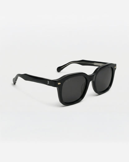 Black sunglasses with a thick frame on a plain background