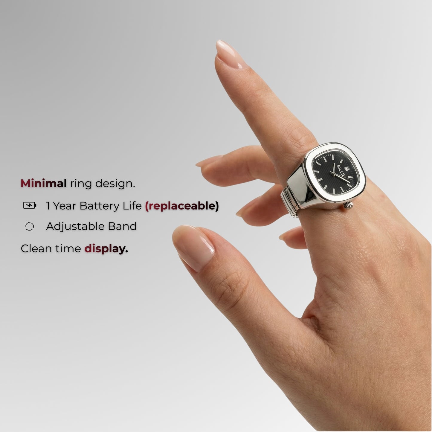 Hand wearing a ring with a watch face on a gray background