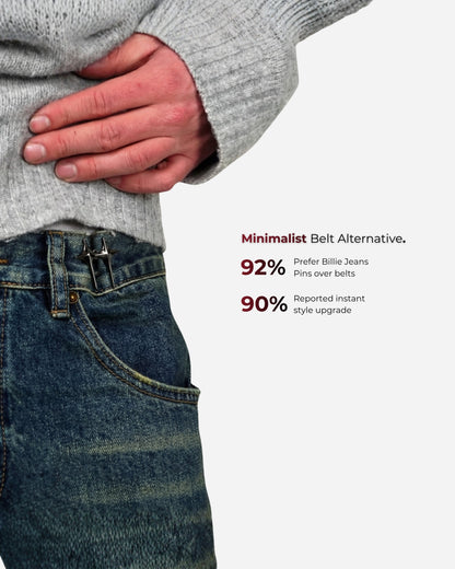 Person wearing a gray sweater with hand on hip, showing denim jeans and text on the side.