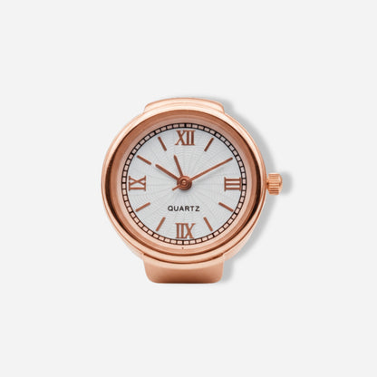 Rose gold ring watch with white face and Roman numerals on a light gray background
