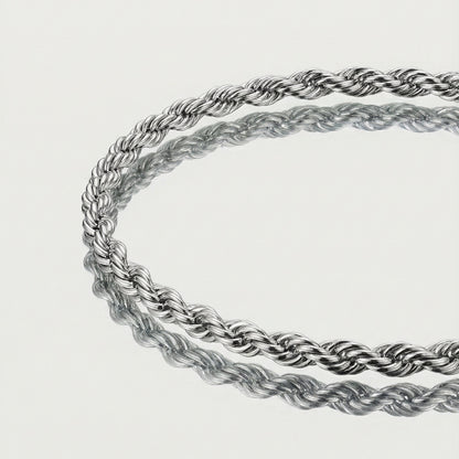Two silver rope chains on a light gray background