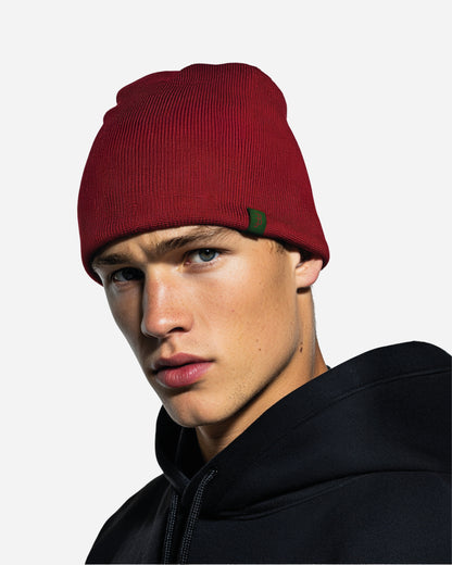 Close-up of a person wearing a red beanie and a black hoodie.
