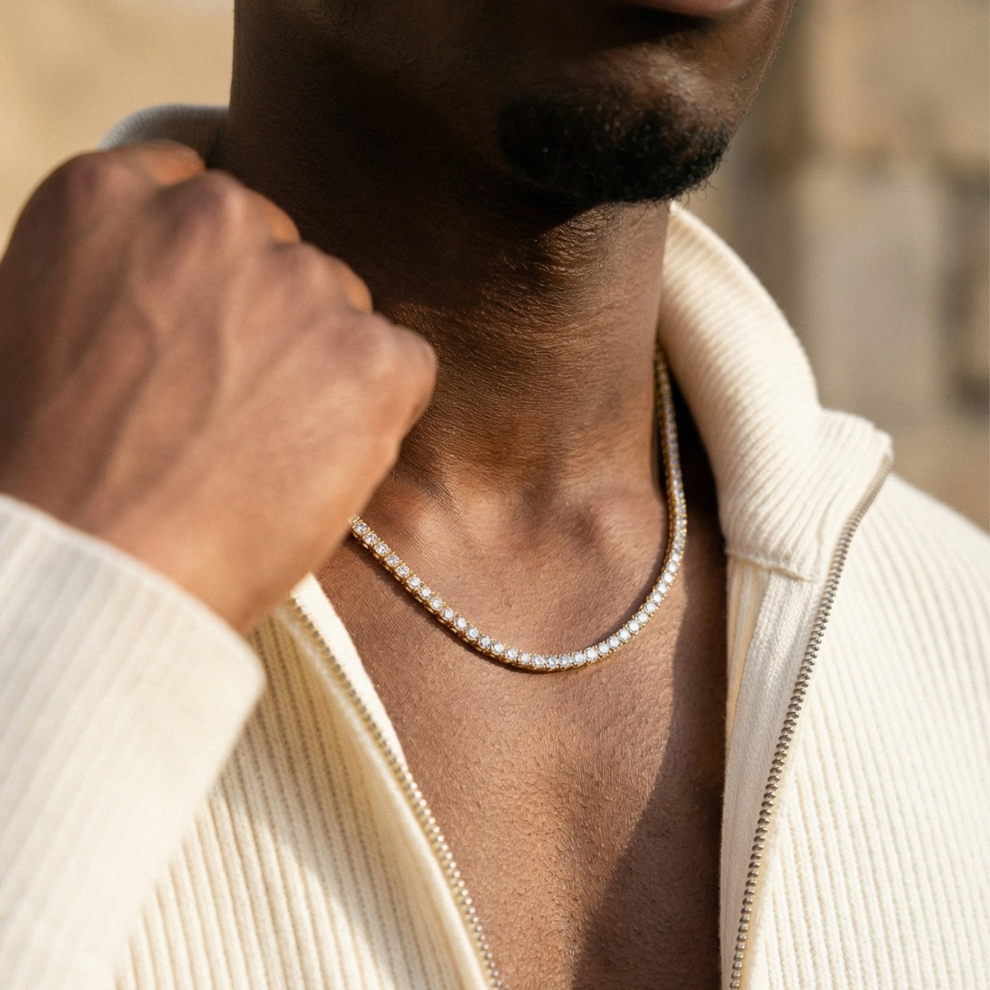 Man wearing a diamond necklace with a blurred background