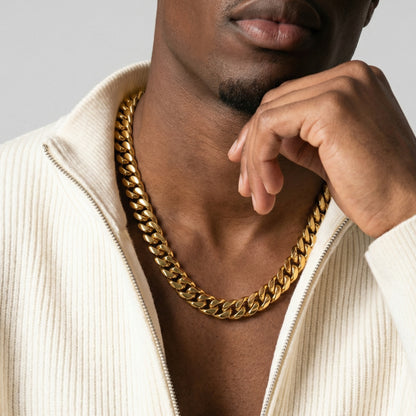 Man wearing a gold chain necklace with a neutral background