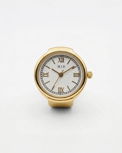 Billie Grace Ring Watch in gold, round finger watch with Roman numerals and white dial on a light background