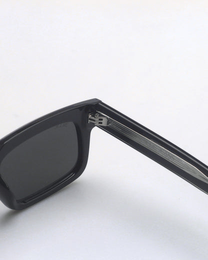Close-up of black sunglasses with dark lenses and silver detailing on the arm.