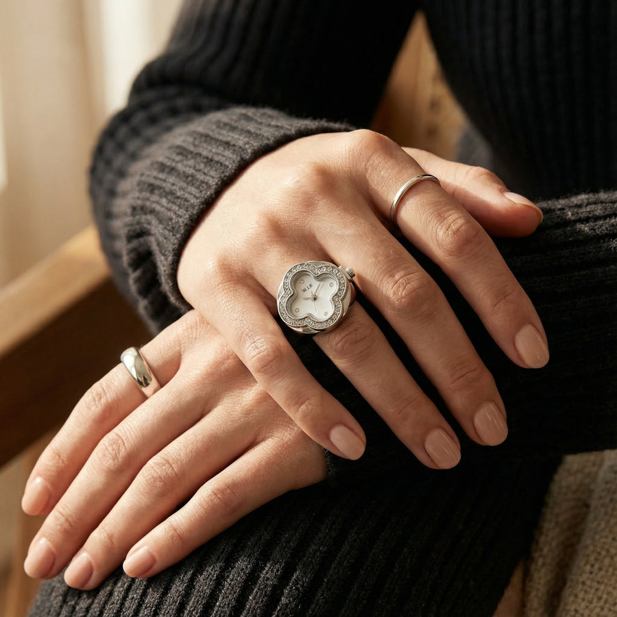 Close-up of hands wearing rings with a textured ring on a blurred background