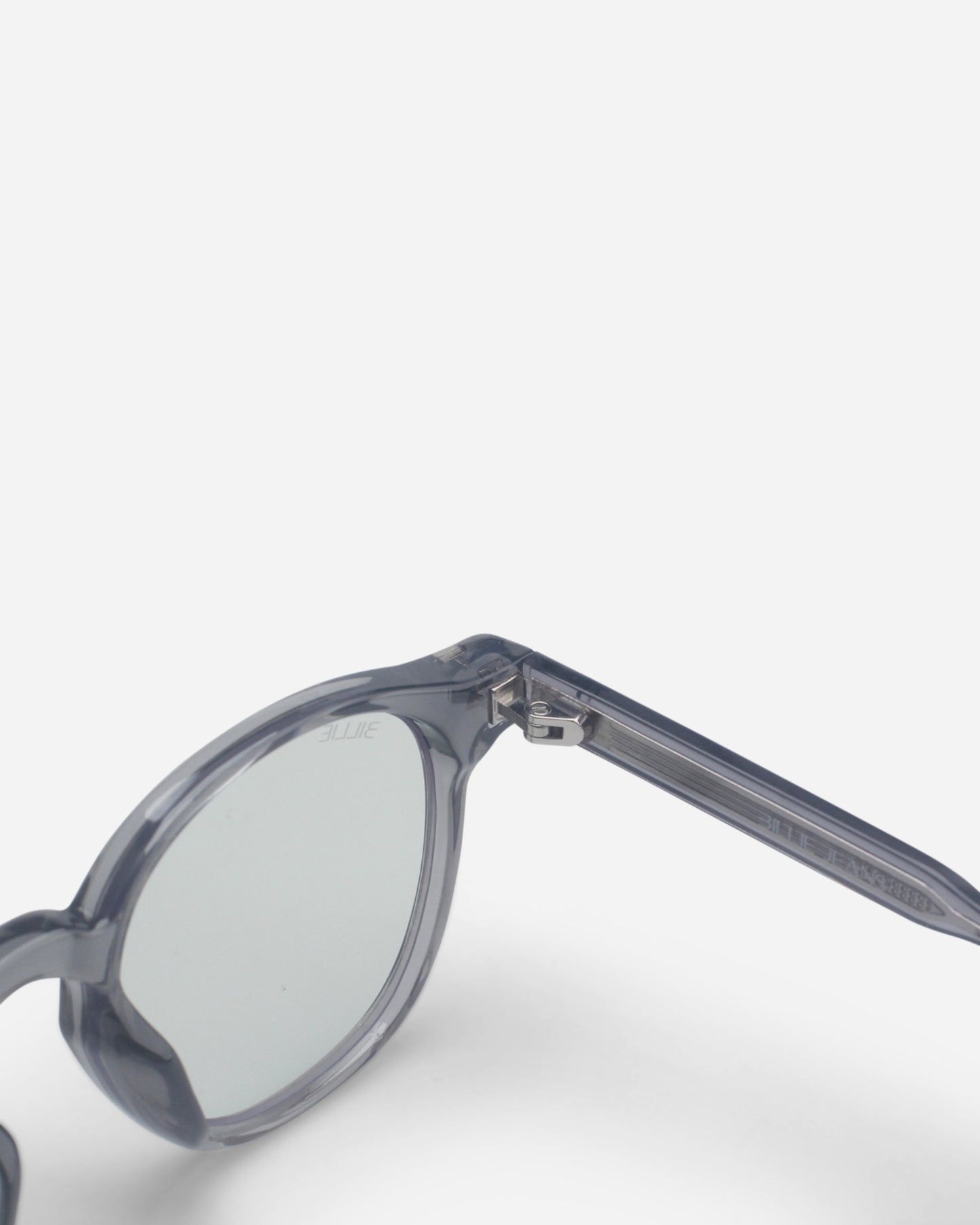 Close-up of round sunglasses with transparent gray frames and clear lenses.