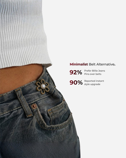 Close-up of a waist with a decorative pin on denim jeans and a white ribbed top.