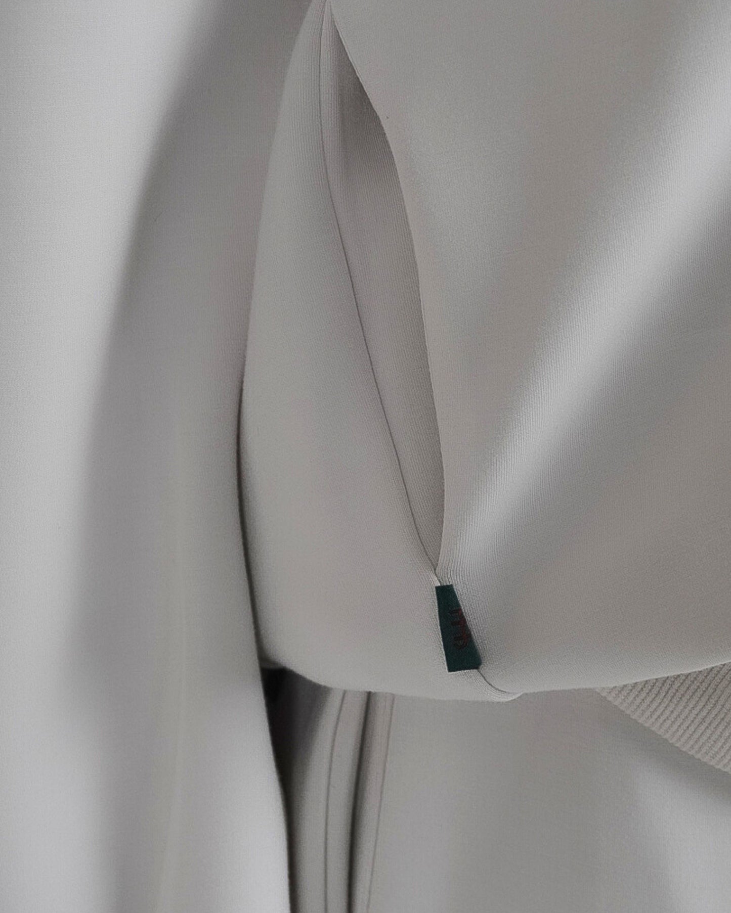 Close-up of a light gray fabric with a small tag visible.