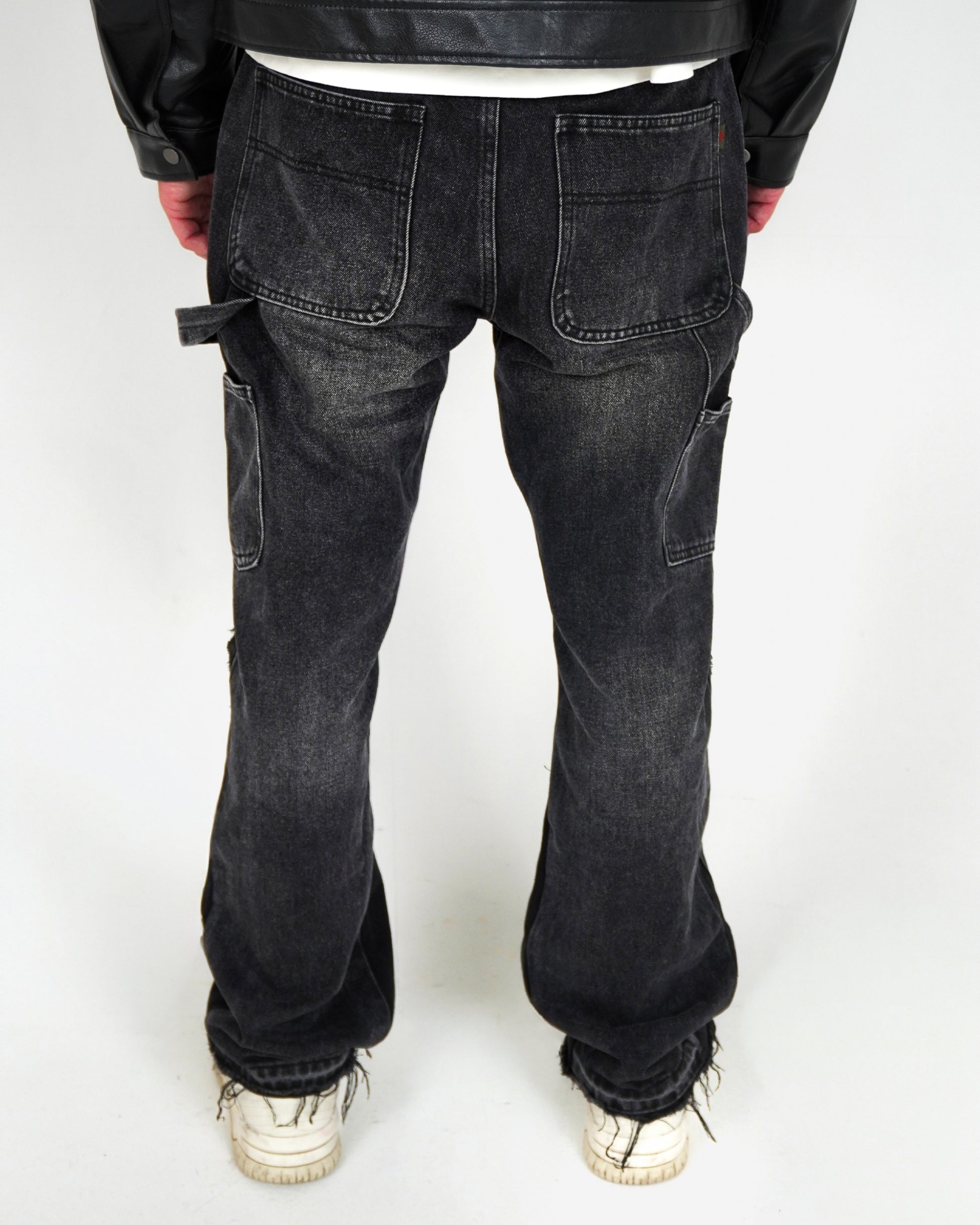 Person wearing black jeans and white sneakers, viewed from the back.