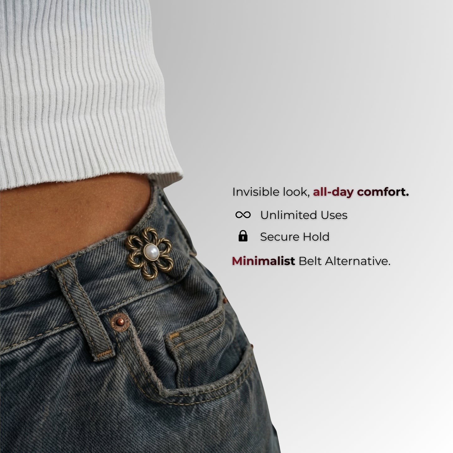 Close-up of a person wearing jeans with a decorative belt buckle on a gray background.