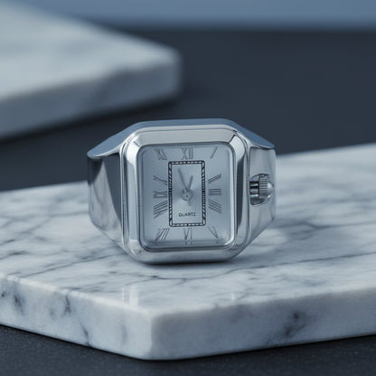 Silver ring watch with a square clock face on a marble surface