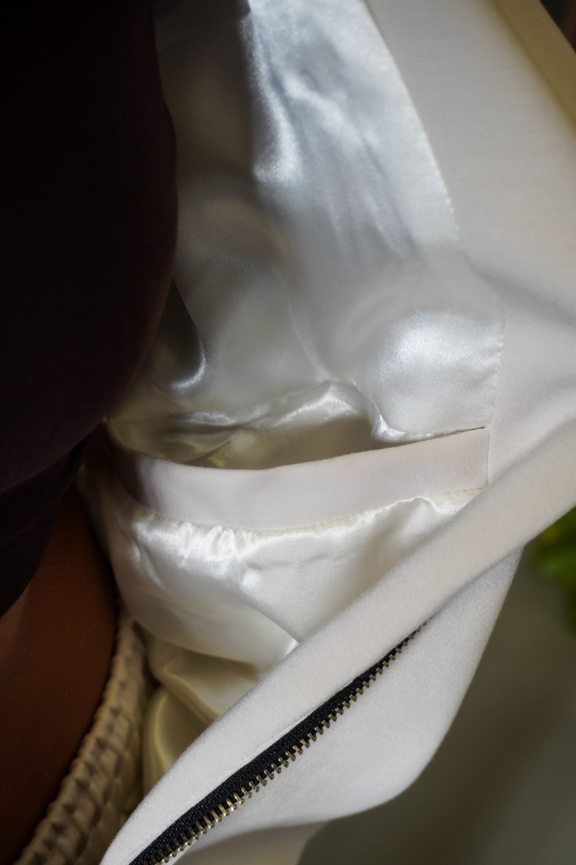 Close-up of a white garment with a zipper on a blurred background