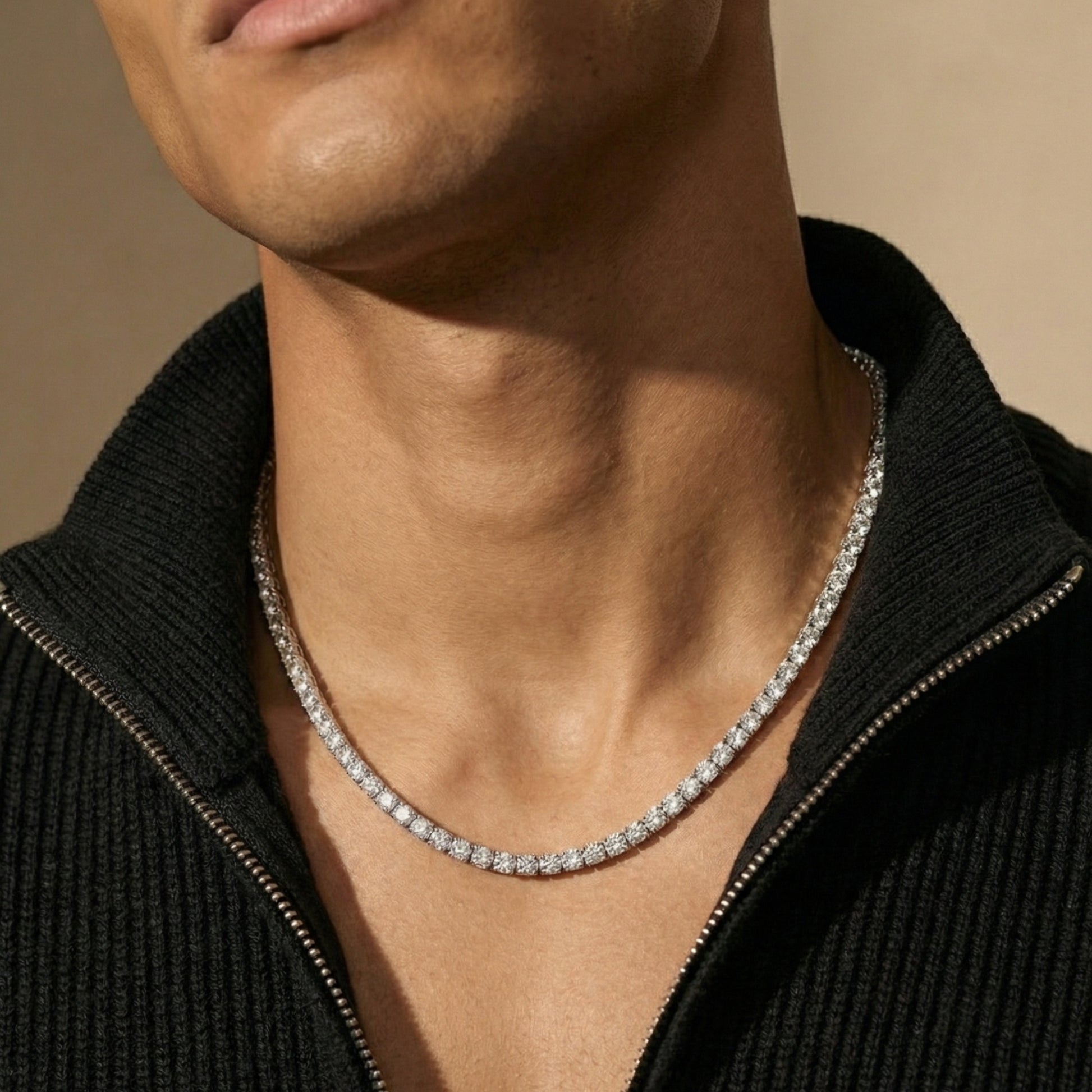 Man wearing a diamond necklace against a neutral background