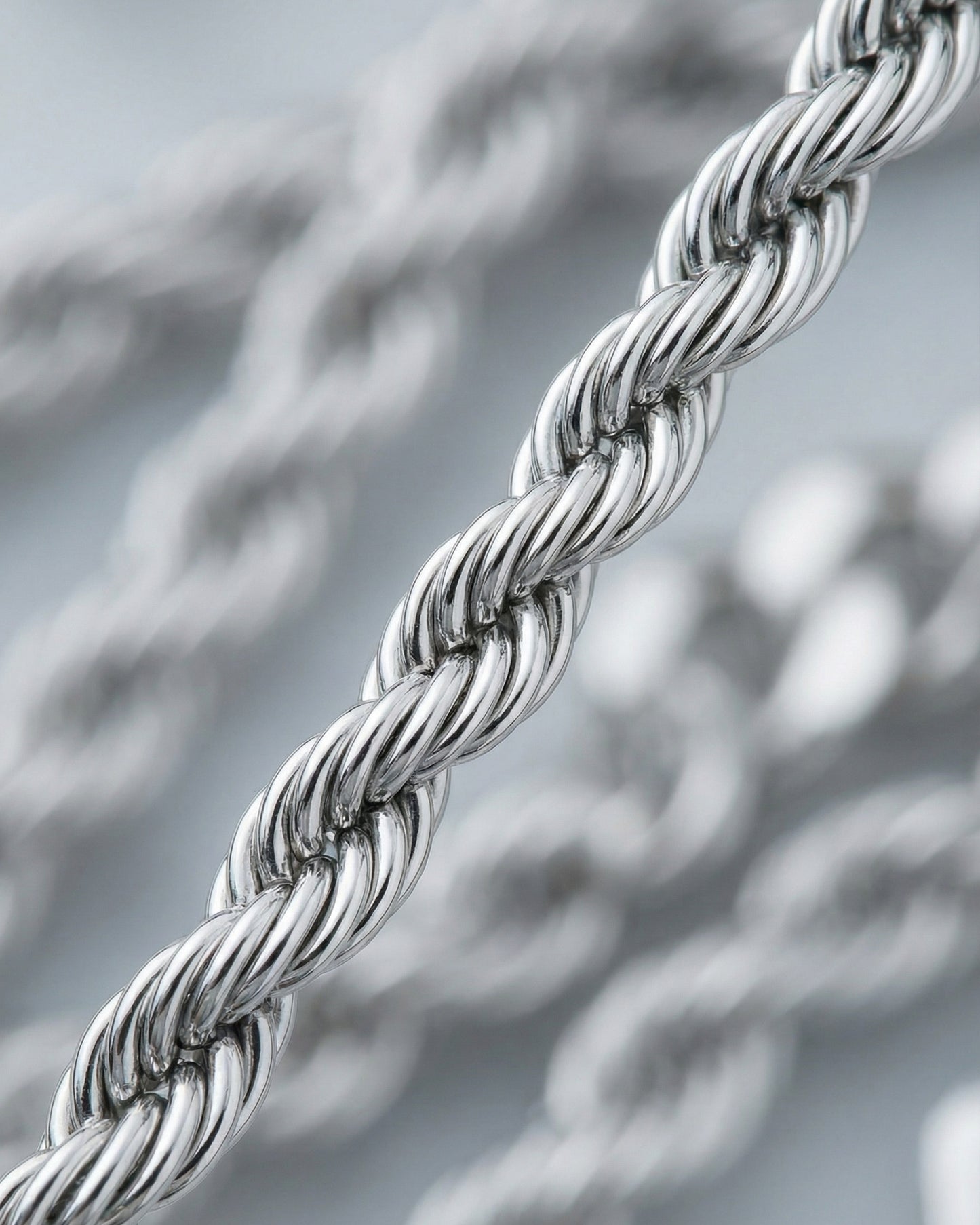 Close-up of a twisted silver chain with a shiny finish.