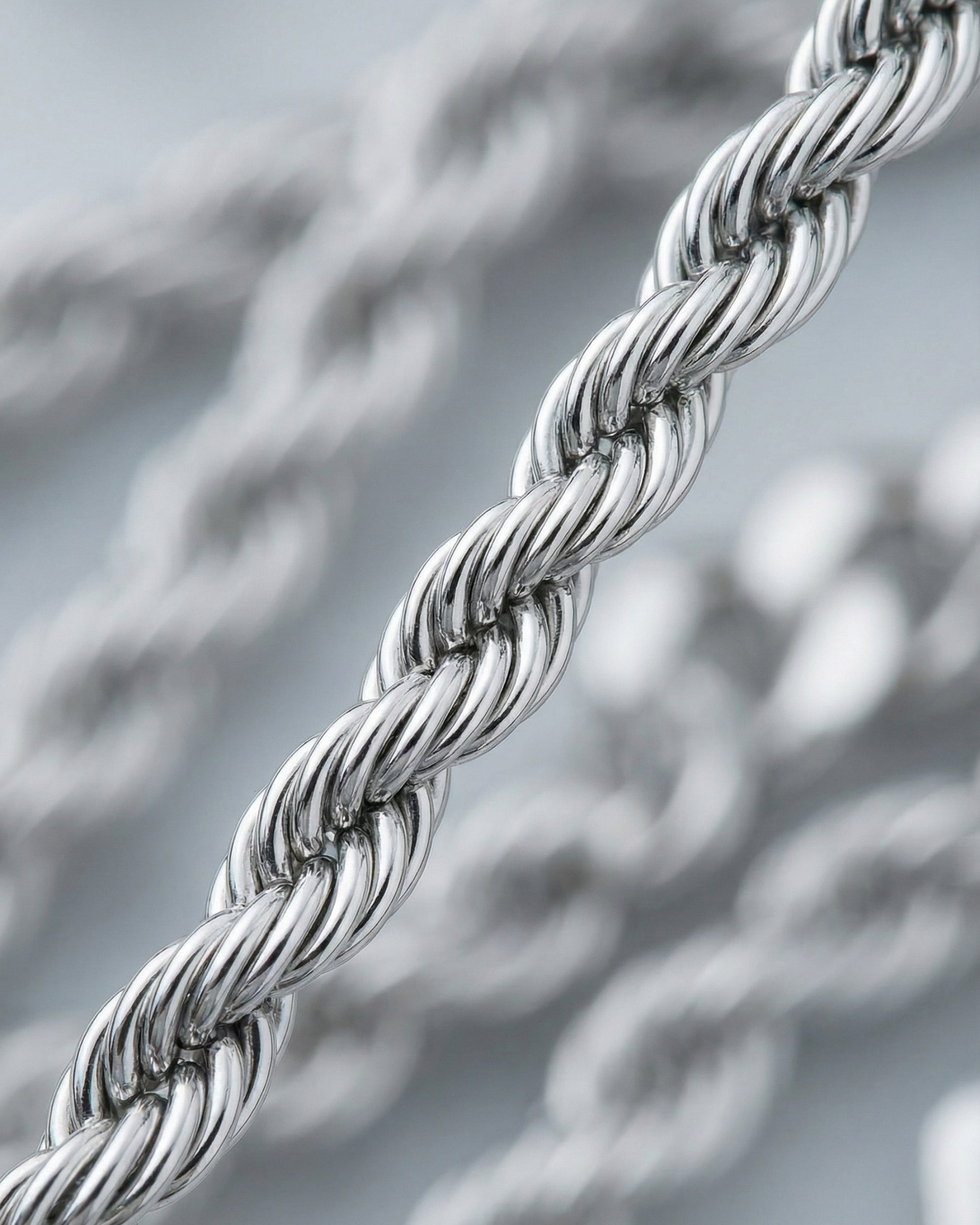 Close-up of a twisted silver chain with a shiny finish.