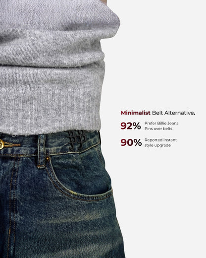 Close-up of a gray sweater and denim jeans with visible text on the side.