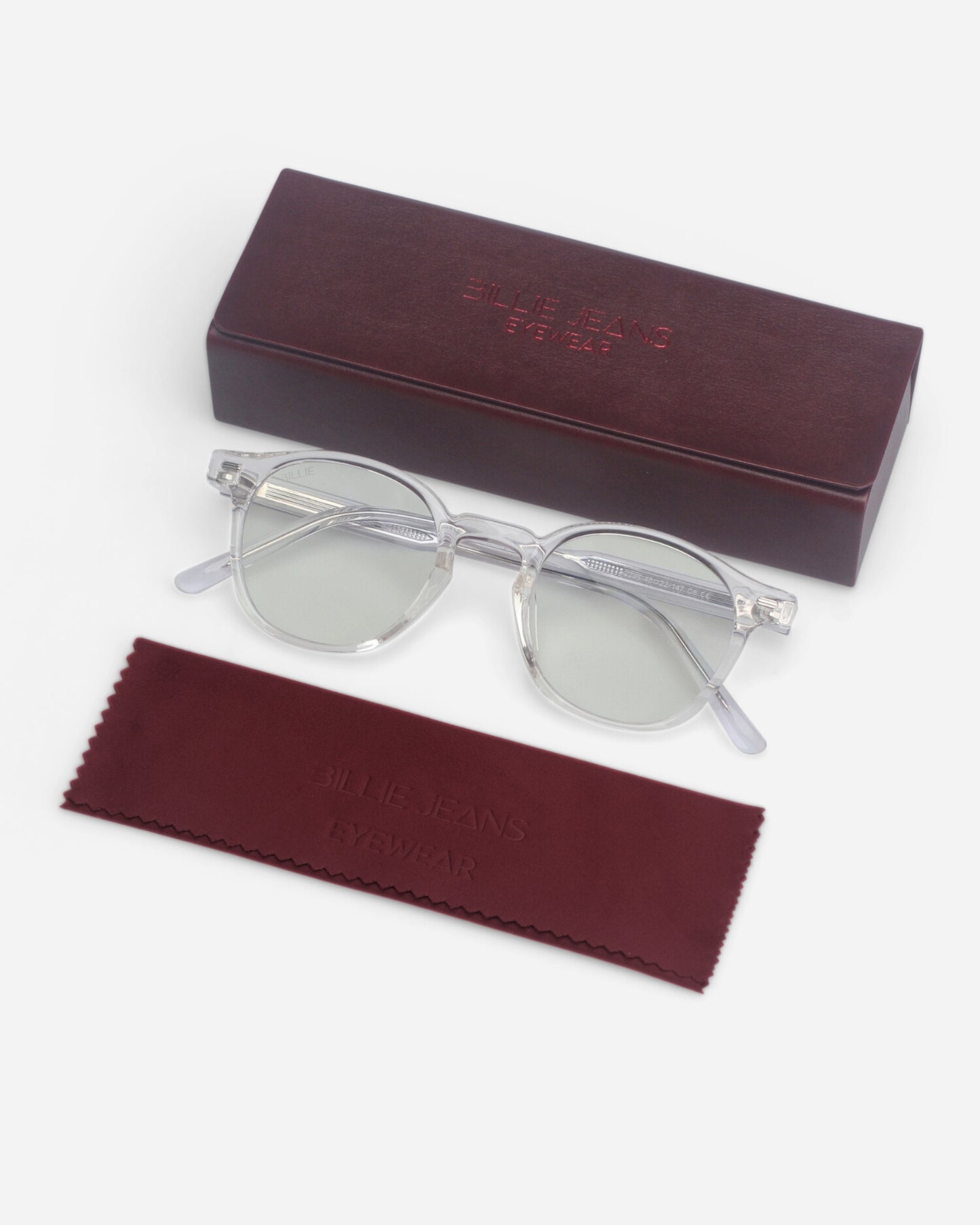 Clear glasses on a maroon case and cleaning cloth with visible text.