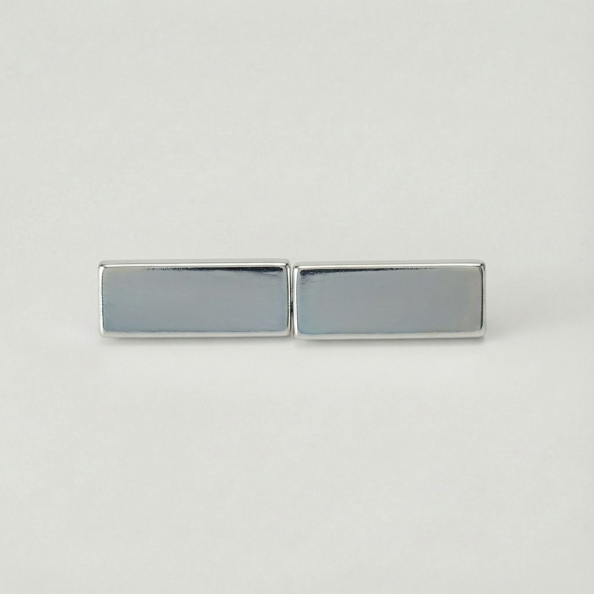 Silver rectangular cufflinks on a light gray background