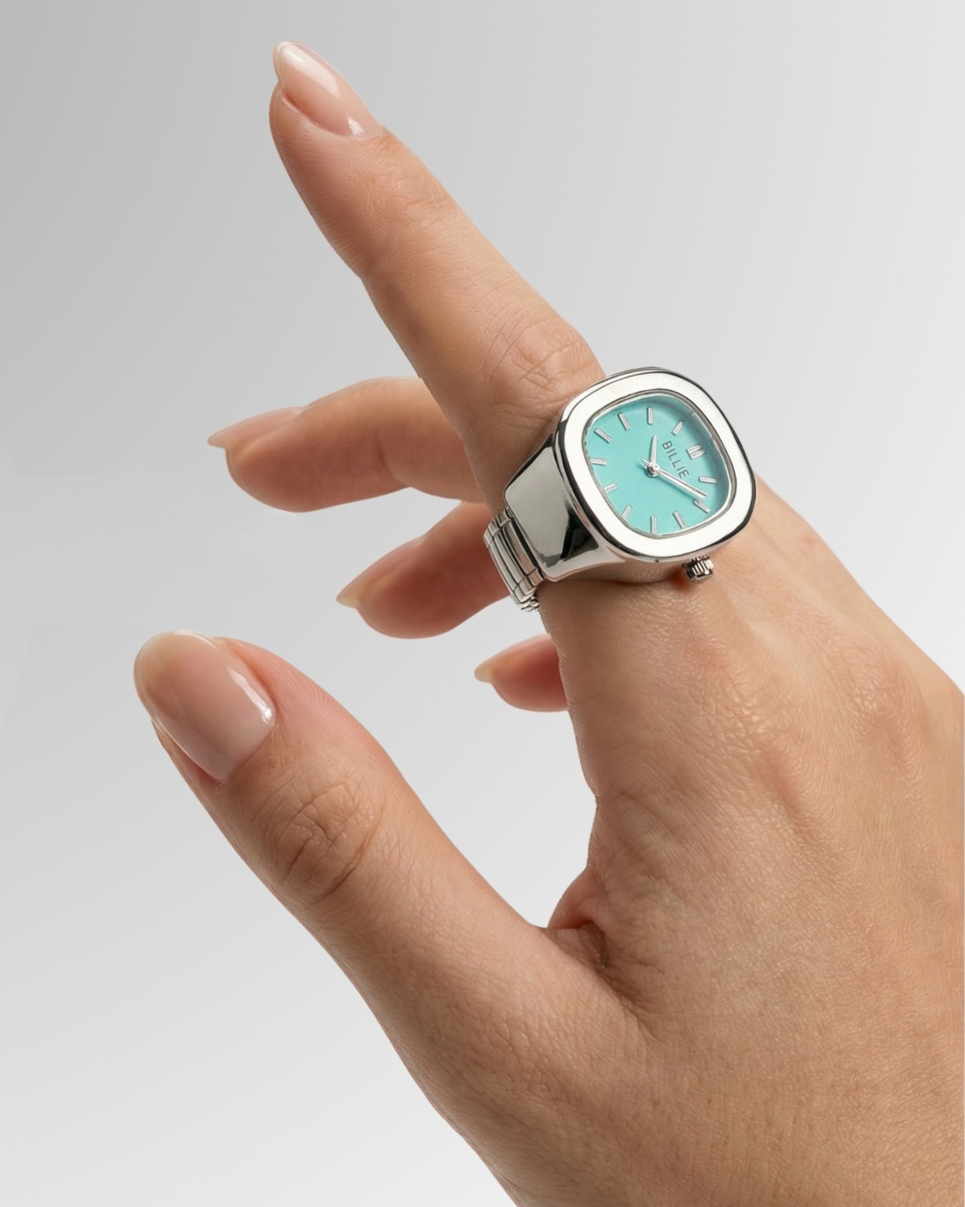 Hand with a silver watch featuring a light blue face and a square shape.