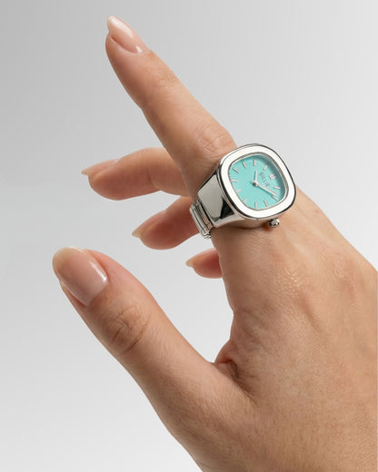 Hand with a silver watch featuring a light blue face and a square shape.