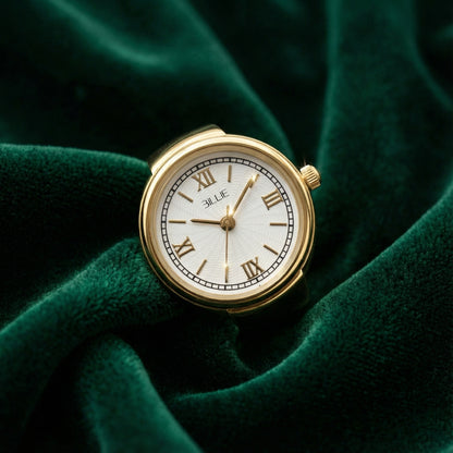Gold watch with white face on a green fabric background