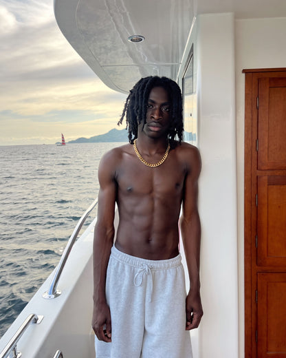 Man wearing the gold Billie Cuban Chain 12mm shirtless on a boat deck