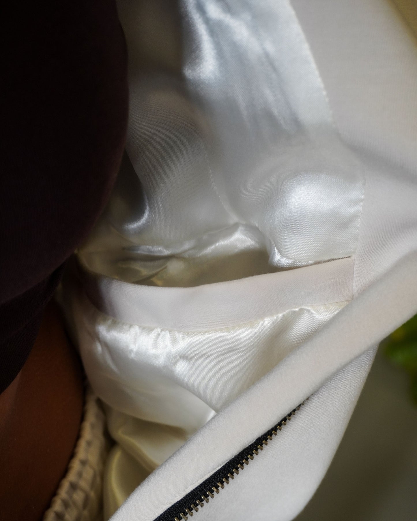 Close-up of a white fabric with a shiny inner lining and a small strap visible.