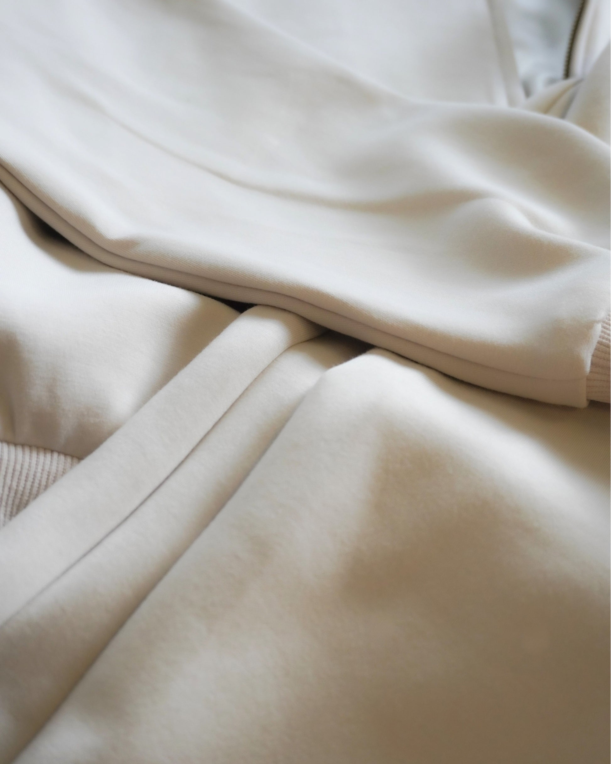 Close-up of folded light-colored fabric layers.