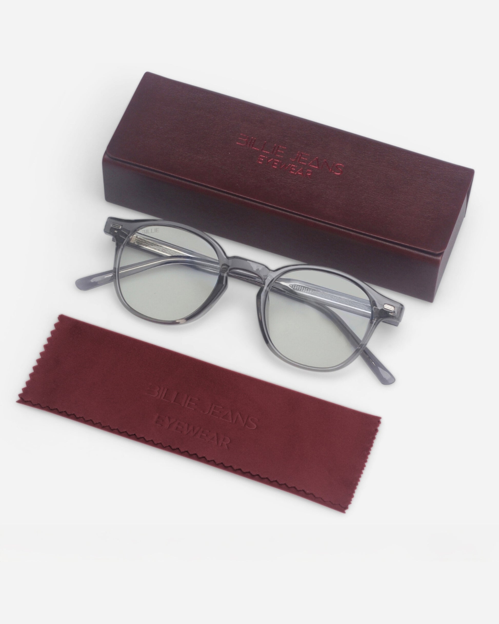 Gray eyeglasses on a white background with a maroon case and cleaning cloth.