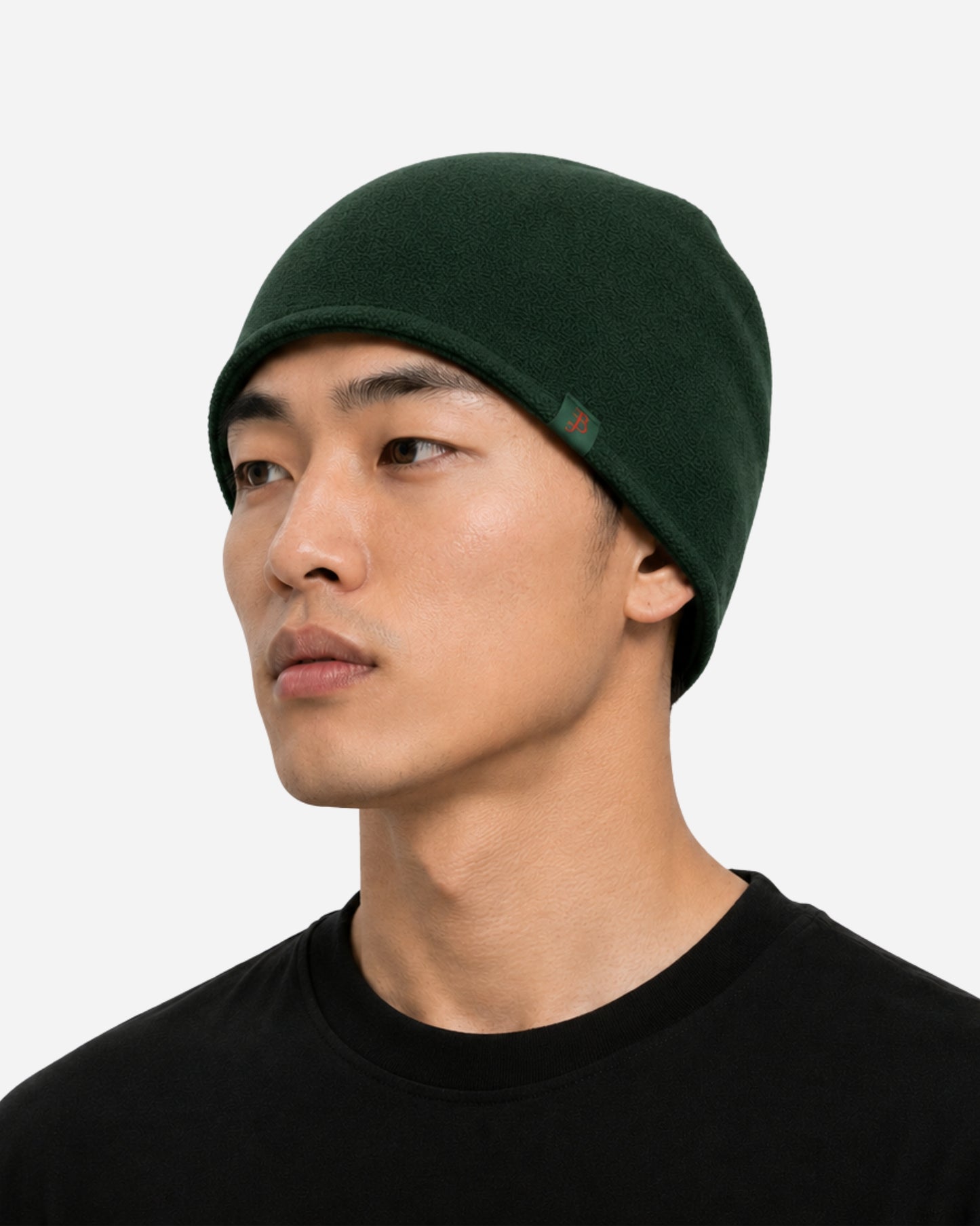 Person wearing a dark green beanie and a black t-shirt, looking to the side.