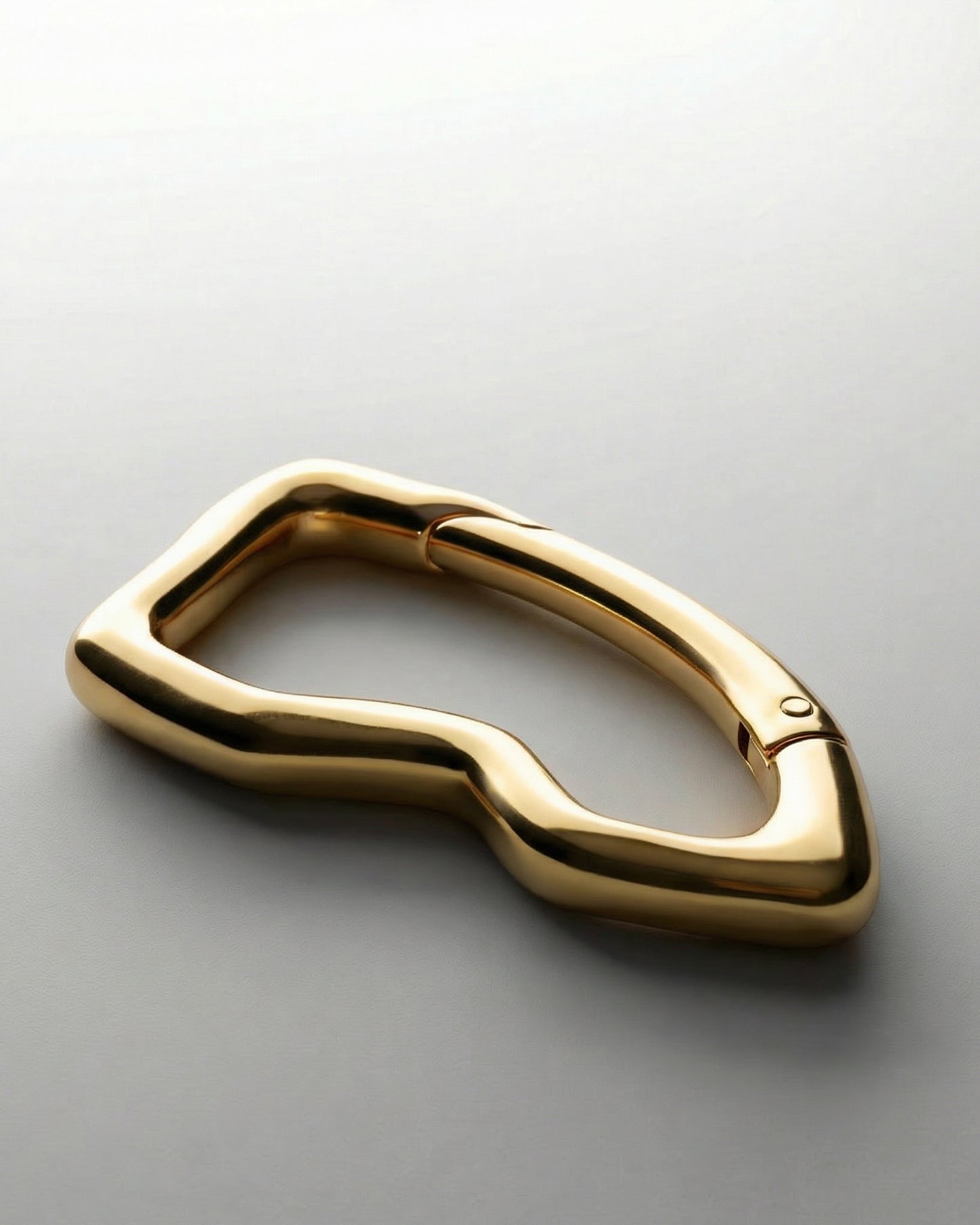 Gold-colored abstract shaped object on a light background