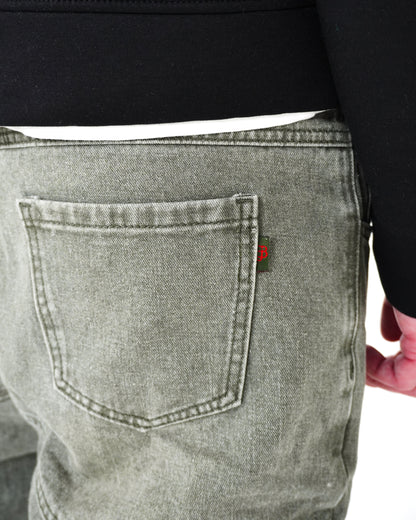 Close-up of back pocket on gray pants with a small red tag.