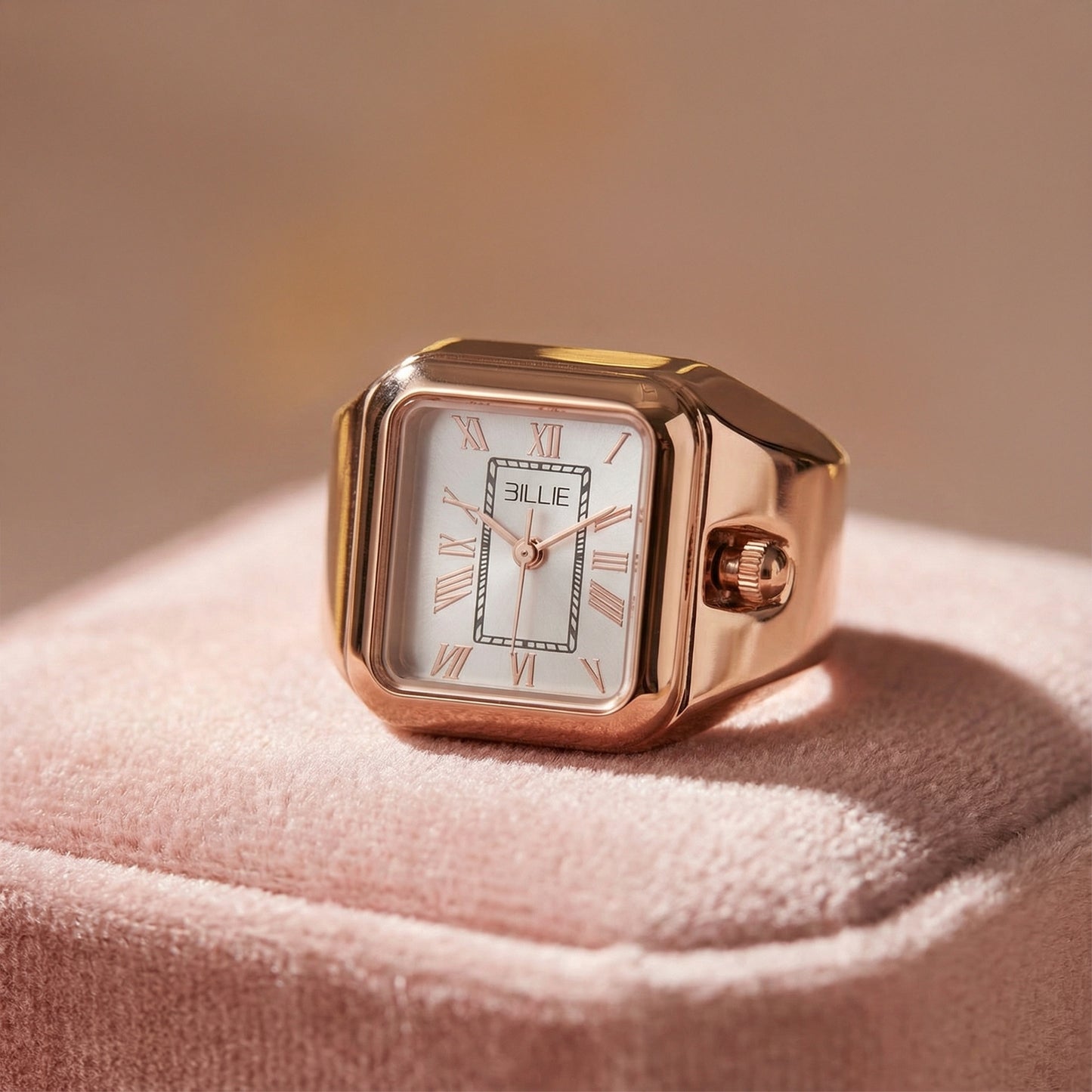 Rose gold watch with white face on a pink fabric background