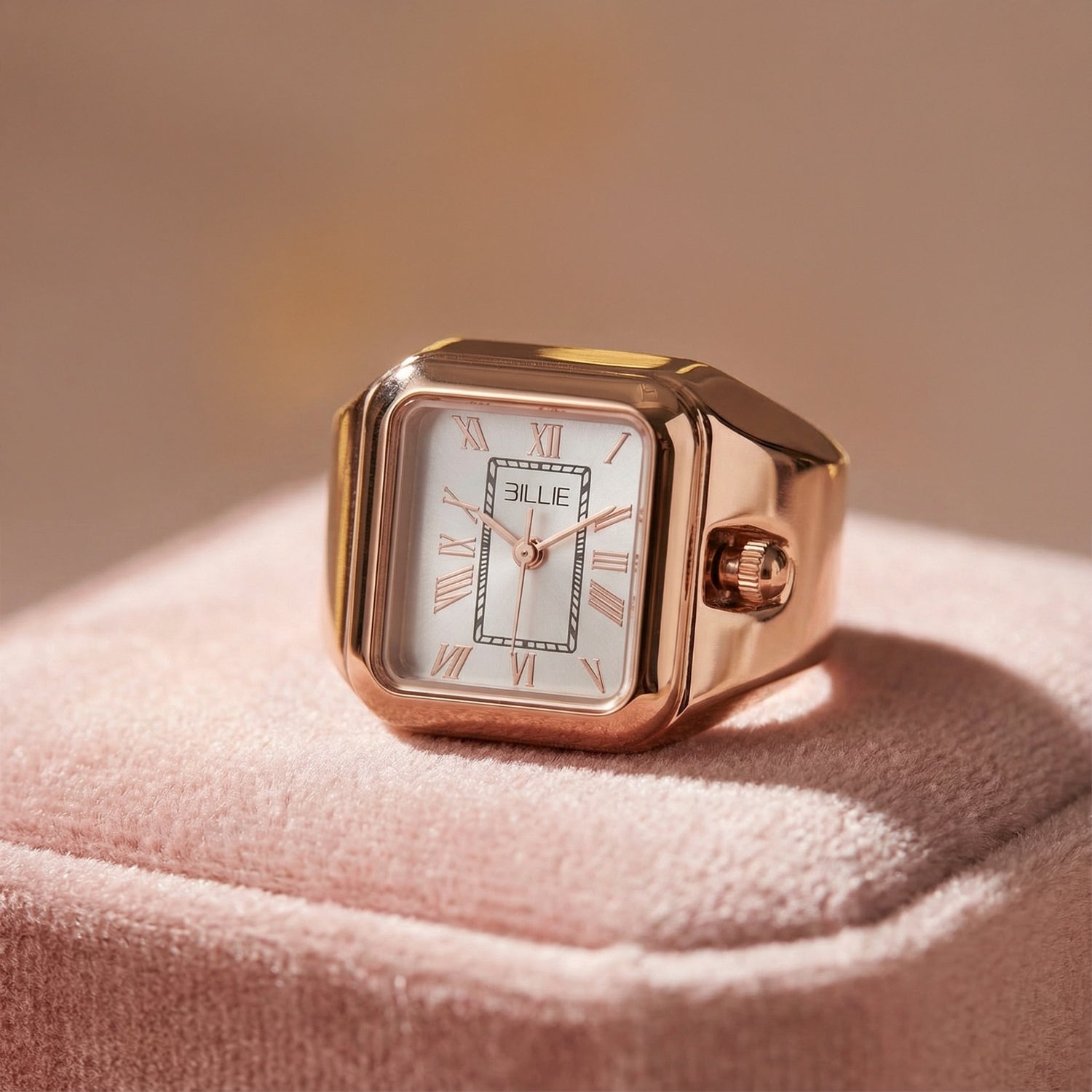 Rose gold watch with white face on a pink fabric background