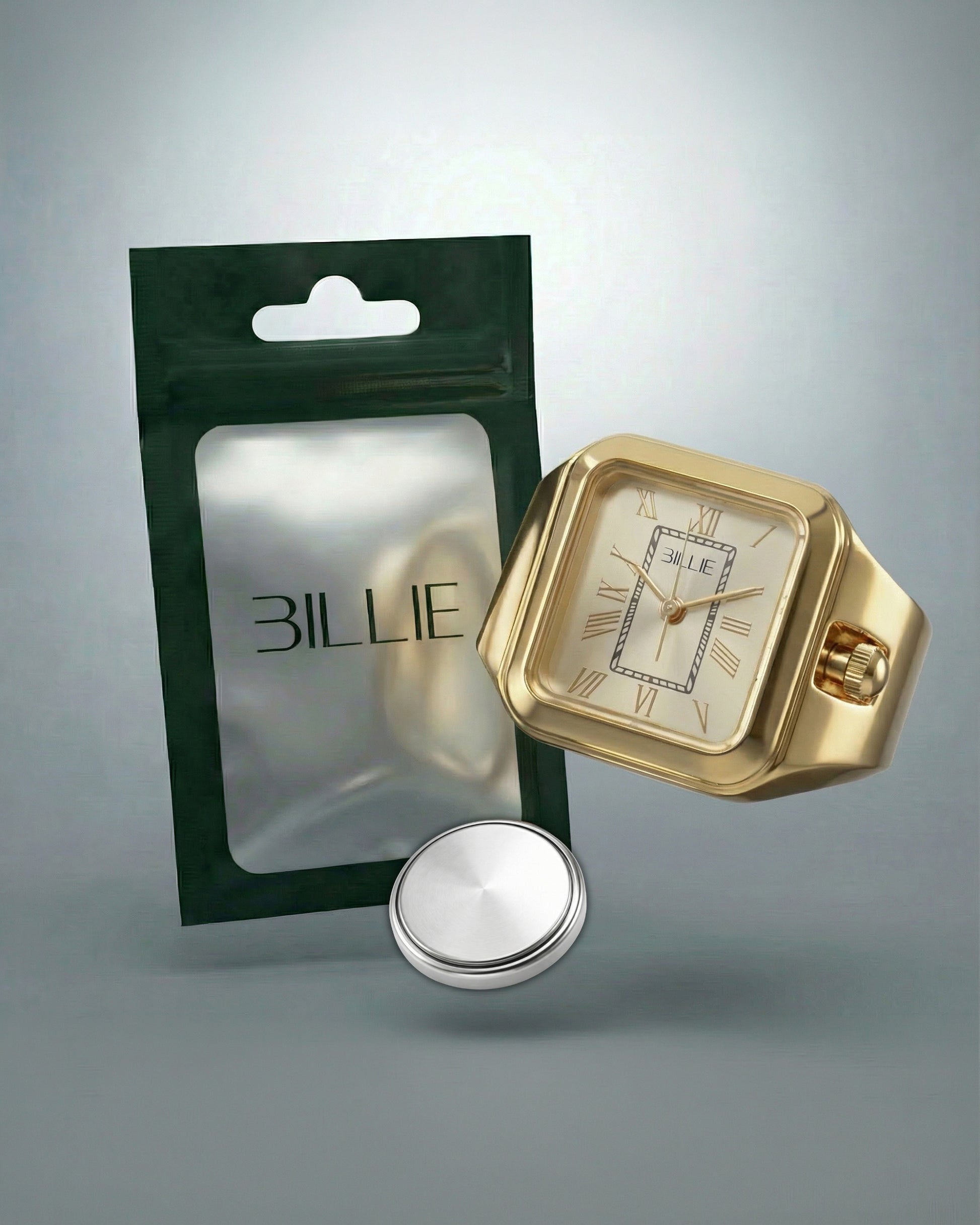 Gold watch with square face, silver button, and green packaging with Billie logo.