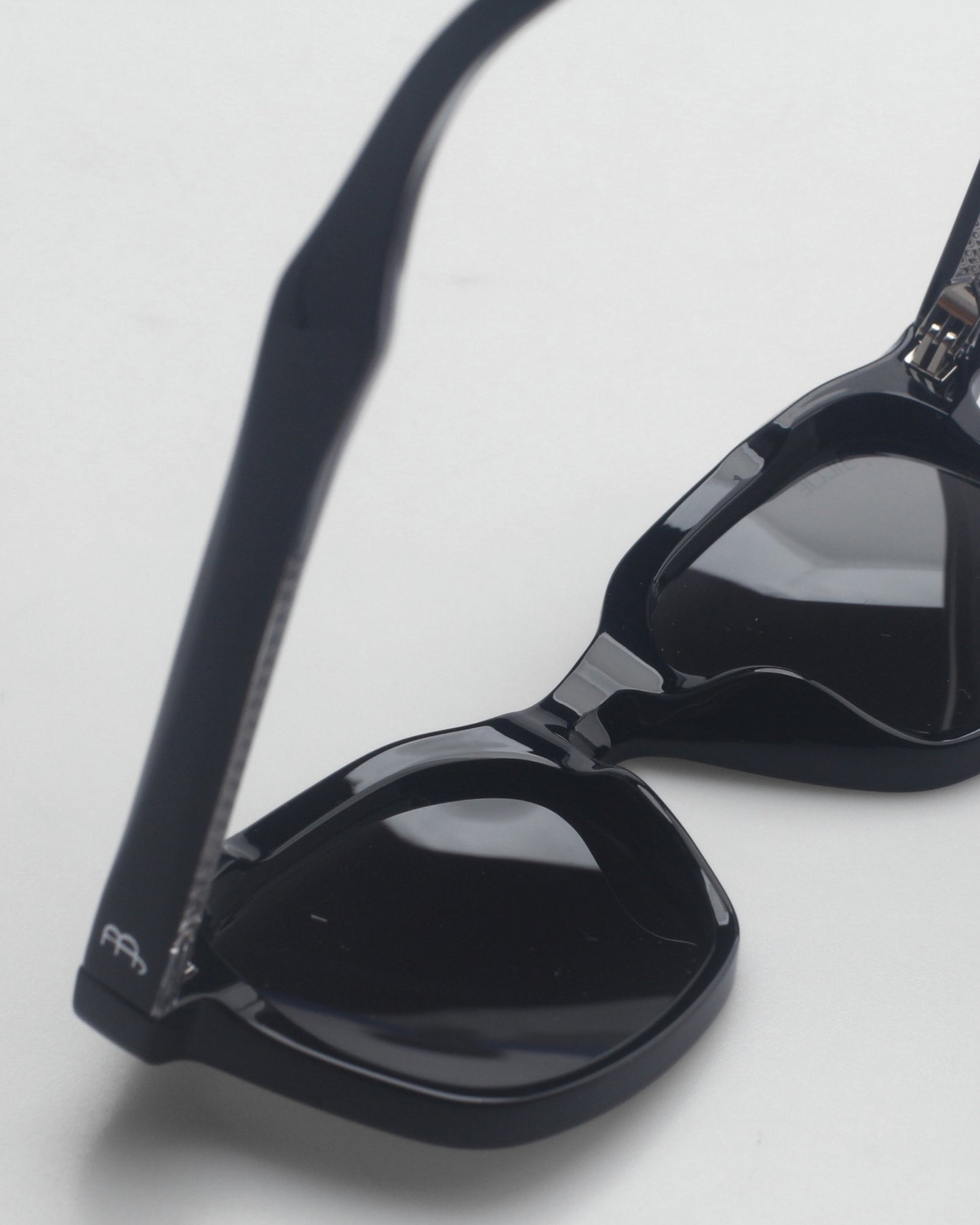 Close-up of black sunglasses on a light background.