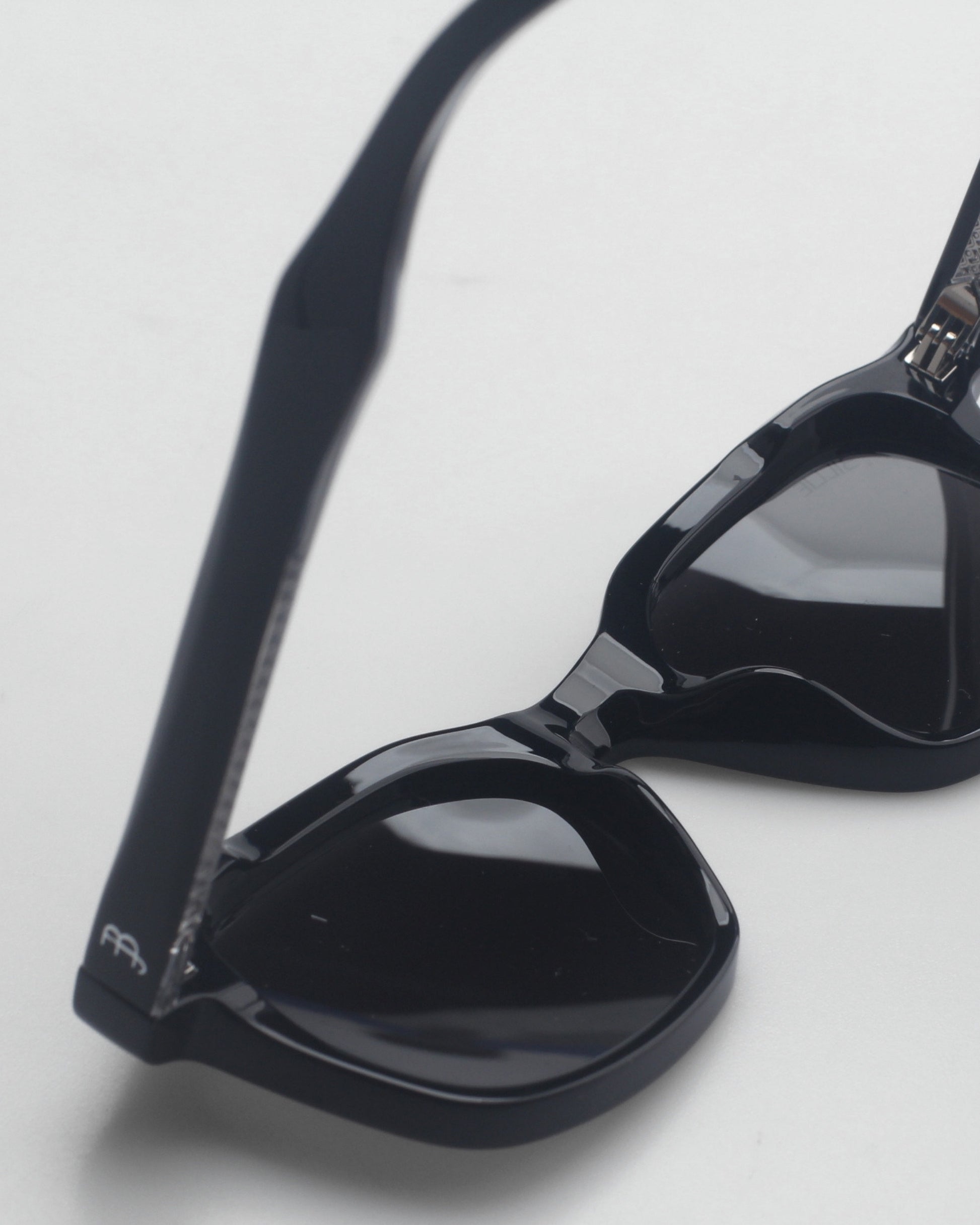 Close-up of black sunglasses on a light background.