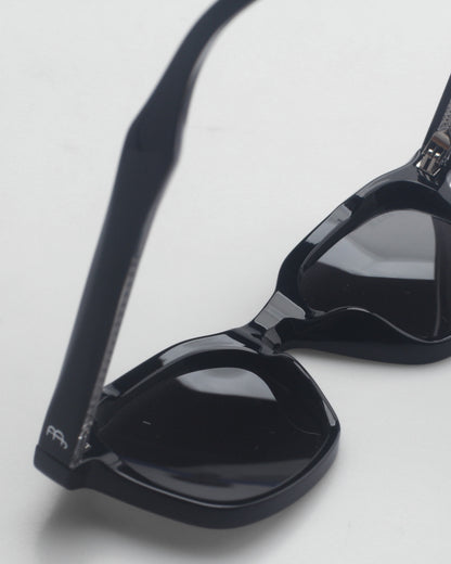 Close-up of black sunglasses on a light background.
