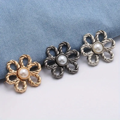 Three waist knotd with pearl centers on a blue fabric background