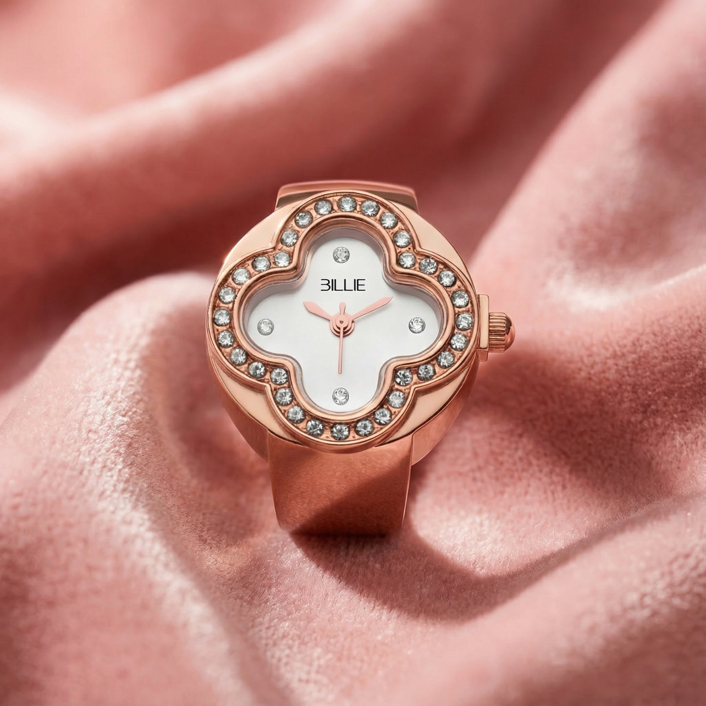 Rose gold watch with diamond accents on a soft pink background