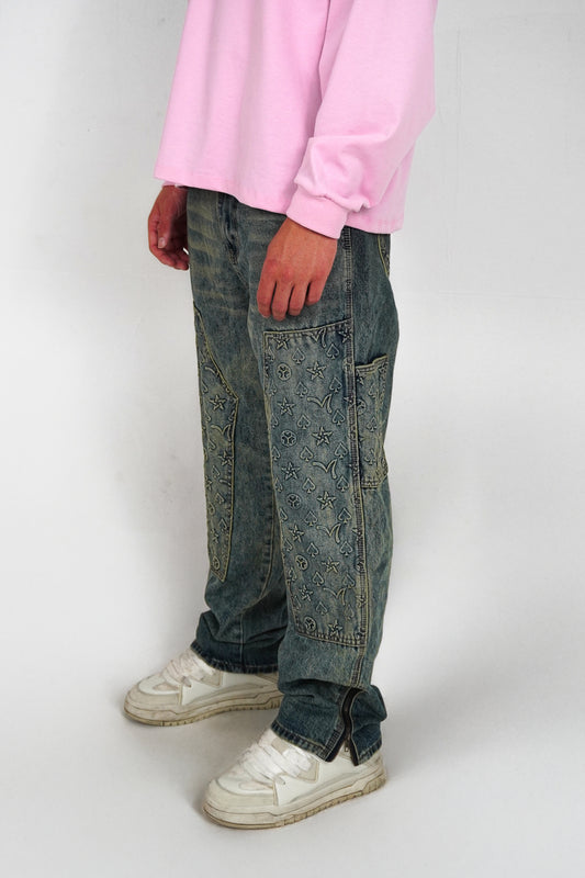 Person wearing a pink sweatshirt, blue jeans, and white sneakers on a plain background