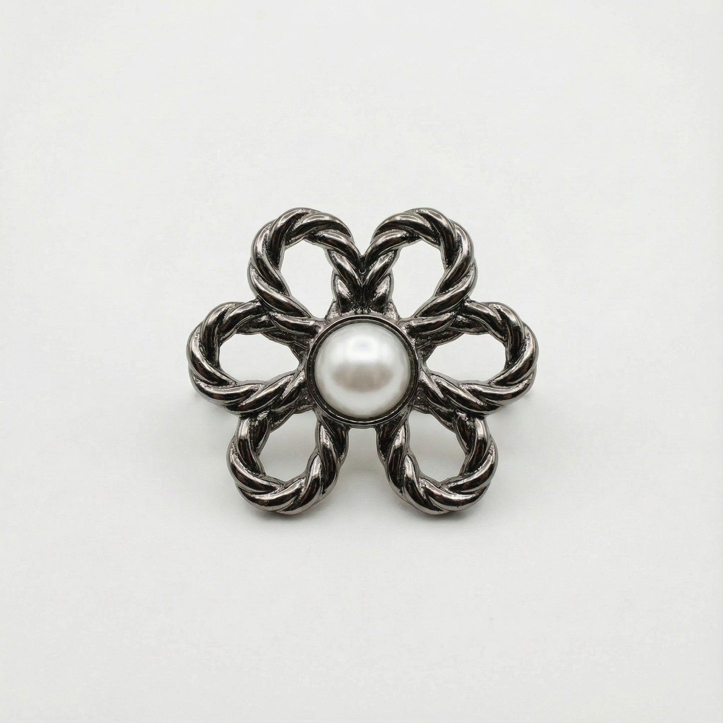 Silver floral brooch with a pearl center on a white background