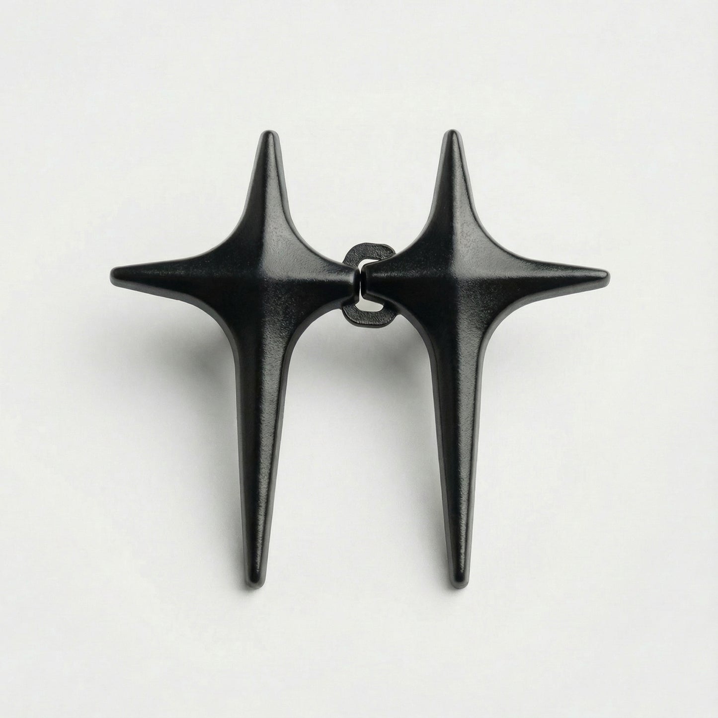 Pair of black star-shaped earrings on a white background