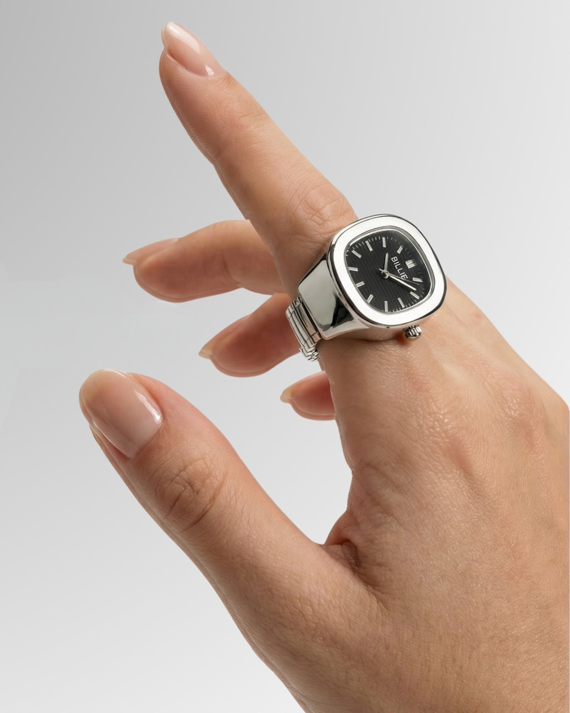 Hand with a silver watch pointing upwards against a gradient background.