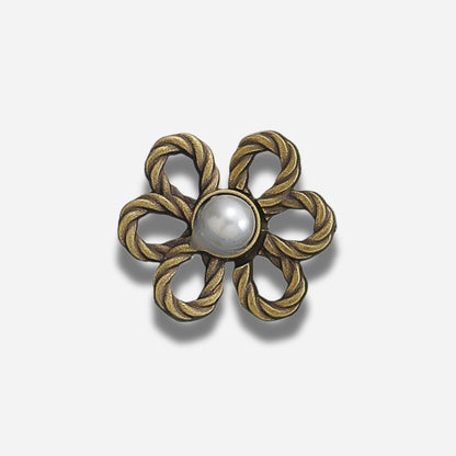 Decoratieve broche met een centrale parel omgeven door een gevlochten gouden ontwerp op een witte achtergrond