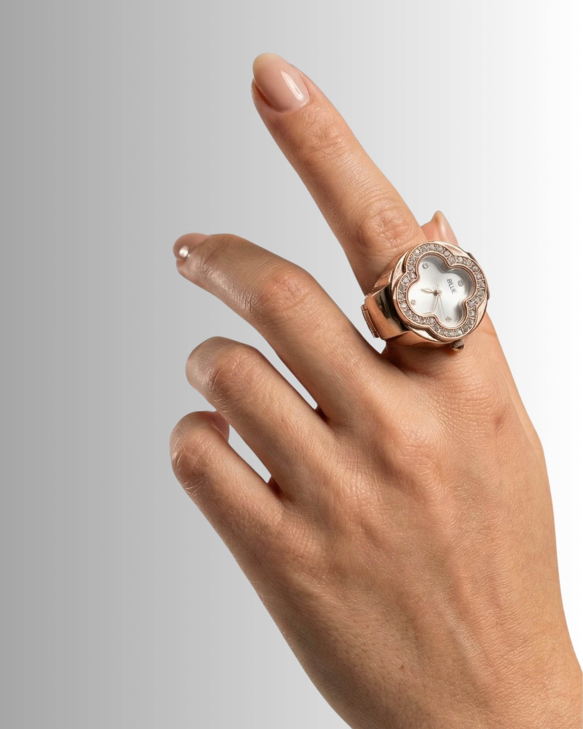 Hand with a ring pointing upwards against a gradient background.